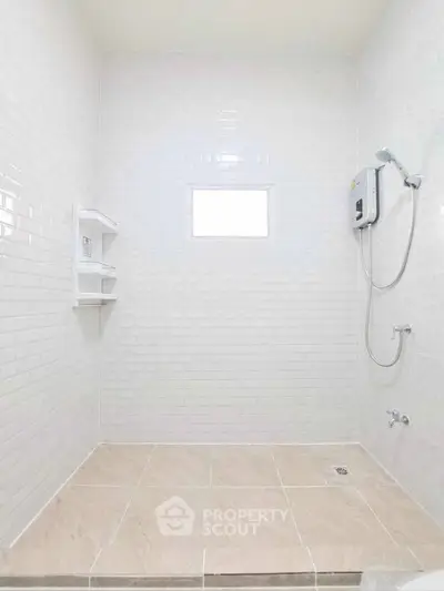Modern minimalist bathroom with white tiles and shower unit, perfect for a sleek and clean home design.