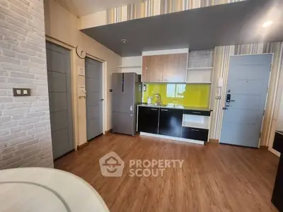 Modern kitchen with open layout, sleek cabinetry, and stainless steel appliances, complemented by a vibrant backsplash and wooden flooring.