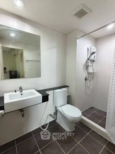 Modern bathroom with sleek fixtures and walk-in shower in a contemporary apartment.