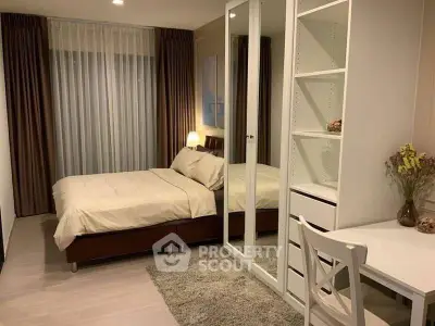 Cozy bedroom with modern decor, mirrored wardrobe, and study desk.