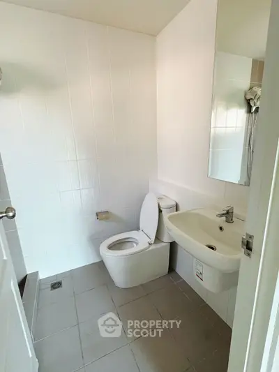 Modern bathroom with white tiles and sleek fixtures in a contemporary home.