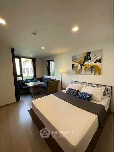 Modern bedroom with stylish decor and cozy seating area, perfect for relaxation.