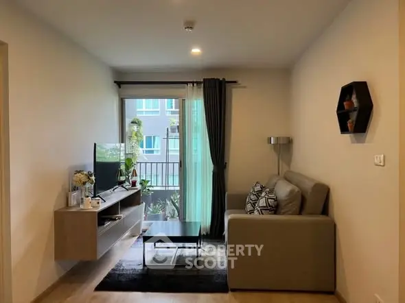 Modern living room with stylish decor and natural light, featuring a cozy sofa and entertainment center.