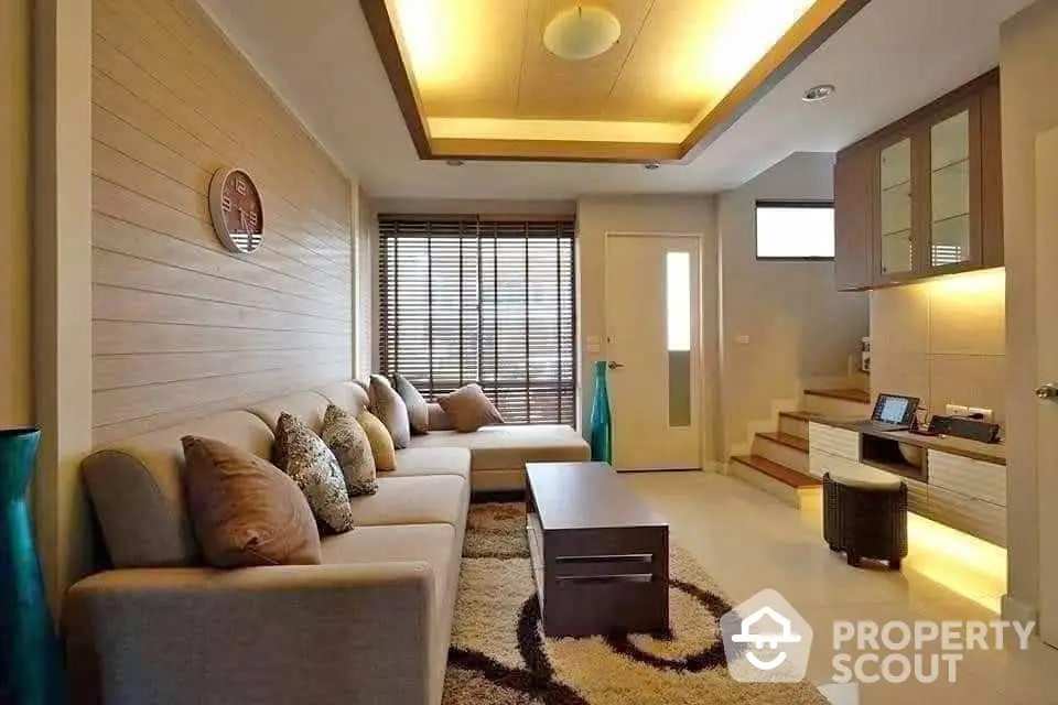 Modern living room with cozy seating and stylish decor, featuring warm lighting and contemporary design.