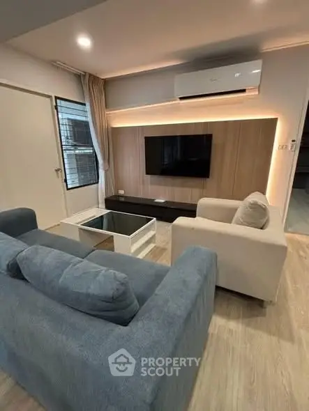 Modern living room with stylish furniture and wall-mounted TV