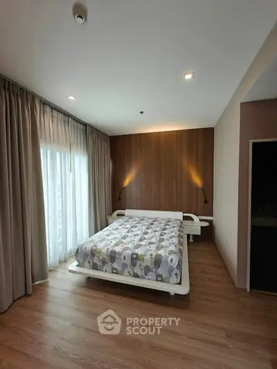 Modern bedroom with wooden accent wall and large window for natural light.
