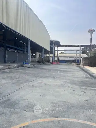 Spacious industrial warehouse exterior with ample concrete yard space.