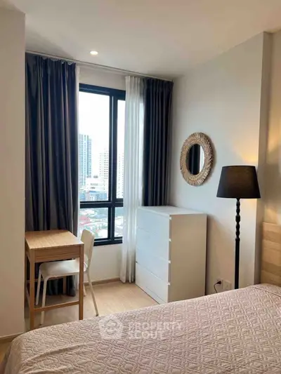 Cozy bedroom with city view, featuring elegant decor and natural light.