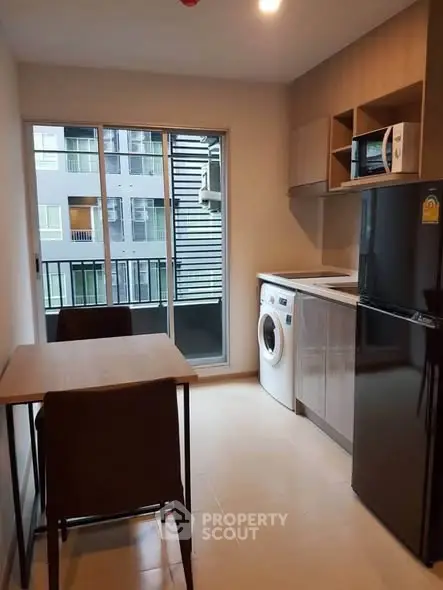 Modern kitchen with washing machine and balcony view in urban apartment