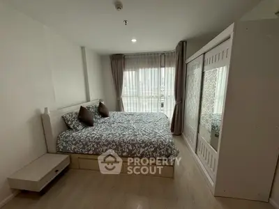 Cozy bedroom with stylish decor and large window for natural light