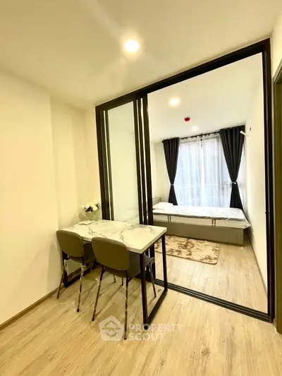 Modern studio apartment with glass partition and elegant dining area