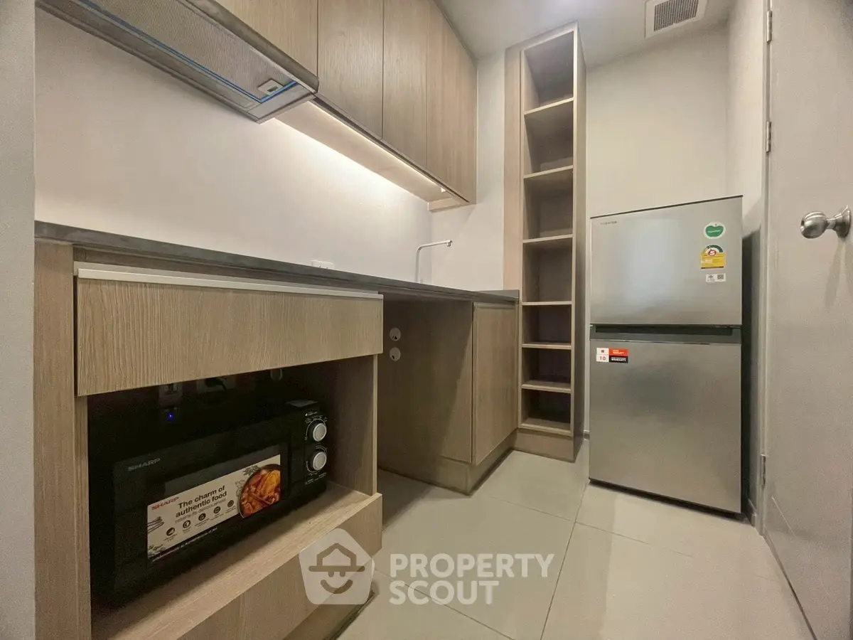 Modern compact kitchen with sleek cabinetry and stainless steel appliances.