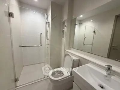 Modern bathroom with glass shower enclosure and sleek fixtures