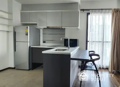 Modern kitchen with sleek design, featuring a breakfast bar and stainless steel appliances.