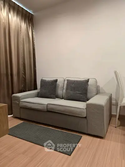 Cozy living room with modern gray sofa and elegant curtains