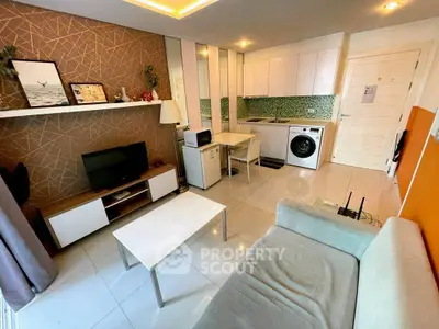 Modern living room with integrated kitchen, featuring sleek appliances and stylish decor.