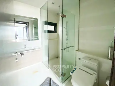 Modern bathroom with glass shower and sleek fixtures in a bright, contemporary design.