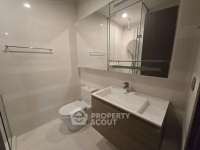 Modern bathroom with sleek fixtures and large mirror in contemporary apartment.