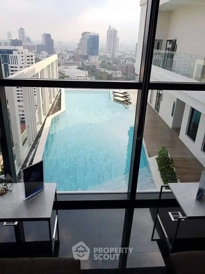 Luxurious rooftop infinity pool with stunning cityscape view in modern high-rise building.