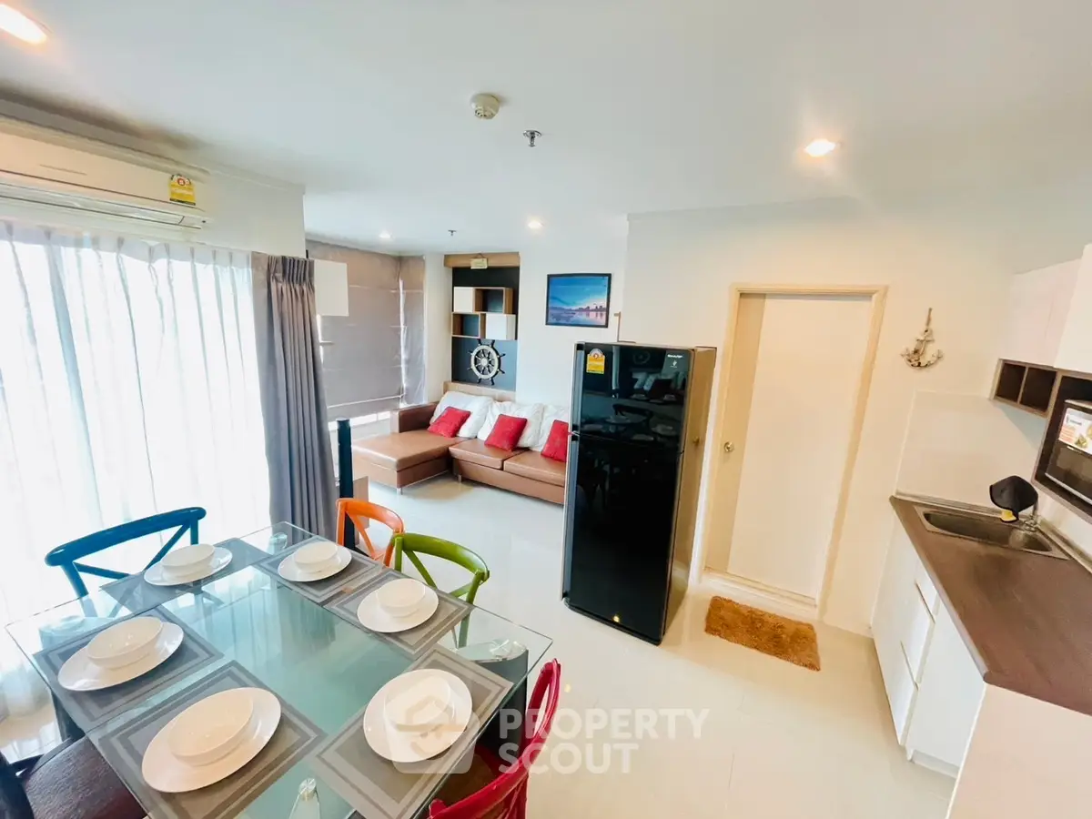 Modern open-plan living room with dining area and sleek kitchen in a stylish apartment.