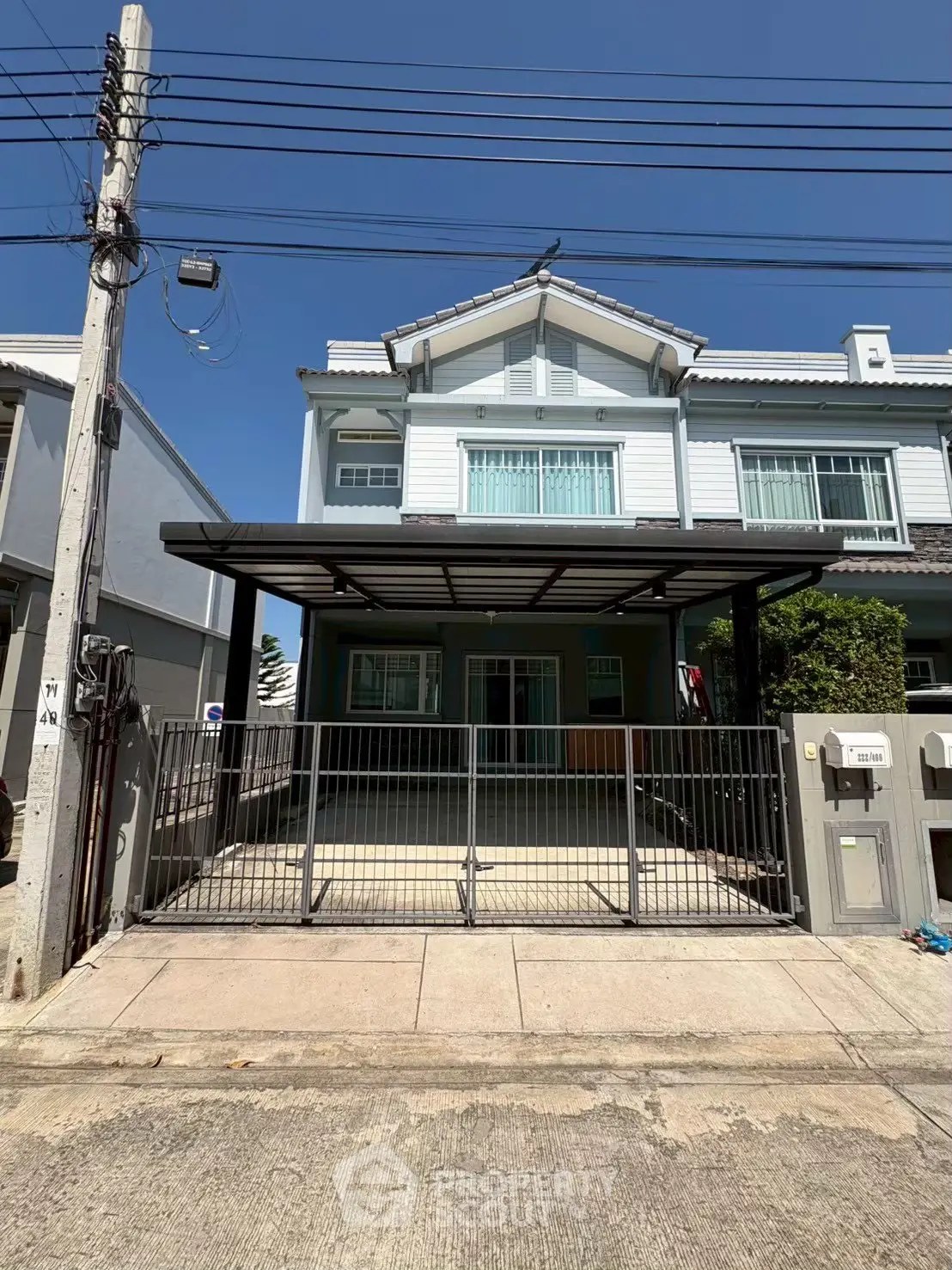 Charming two-story house with gated driveway and modern facade in a serene neighborhood.