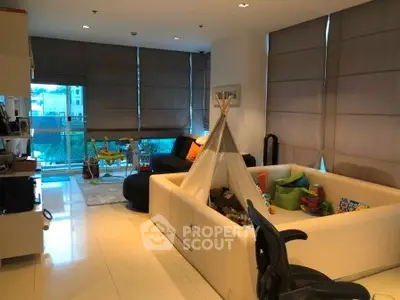 Spacious living room with play area and large windows in modern apartment.