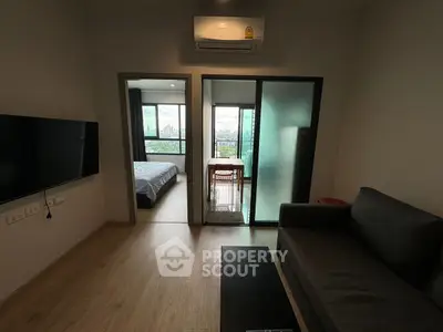 Modern apartment with open layout, featuring a cozy living room and bedroom with city view.
