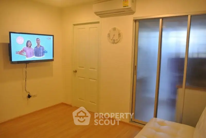 Cozy living room with wall-mounted TV and sliding glass door