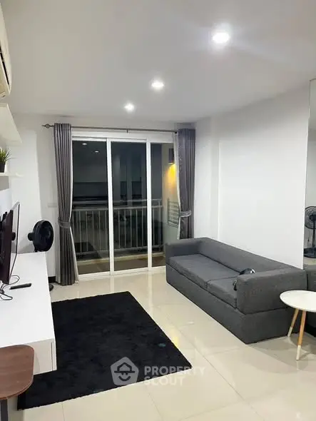 Modern living room with sleek furniture and balcony access in a stylish apartment.