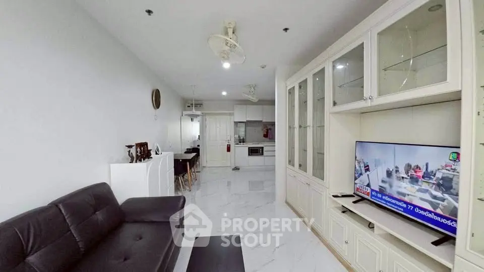 Spacious living room with modern furnishings and open kitchen layout, perfect for contemporary living.