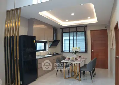 Modern kitchen with sleek cabinetry and dining area, featuring elegant lighting and contemporary design.