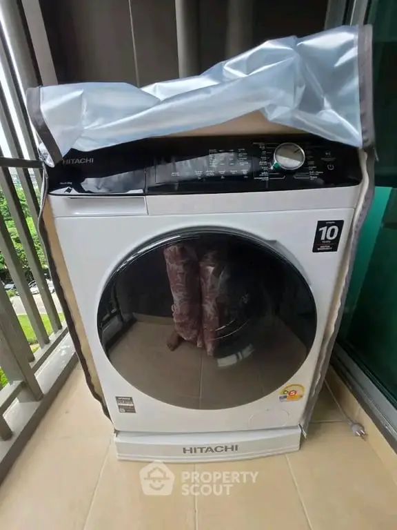 Modern Hitachi washing machine on a balcony, showcasing sleek design and functionality.