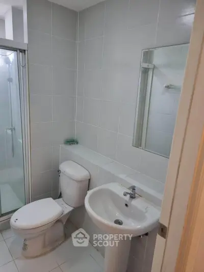 Modern bathroom with shower and sleek fixtures in a contemporary apartment.