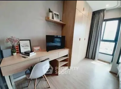 Modern study area with sleek desk, chair, and built-in storage in bright room.