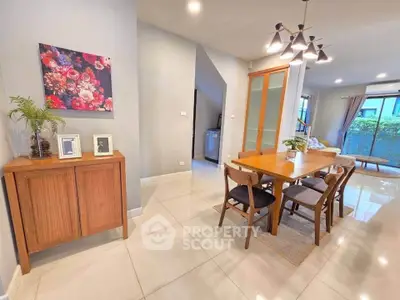 Spacious modern dining area with elegant wooden furniture and stylish lighting in a bright open-plan home.