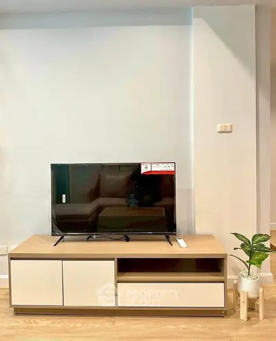 Modern living room with sleek TV stand and flat-screen TV, perfect for cozy entertainment.