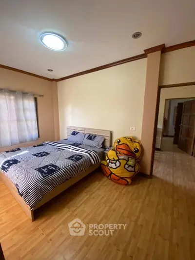 Cozy bedroom with wooden flooring and playful decor