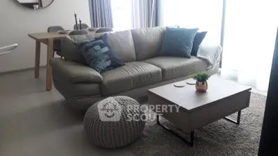 Modern living room with stylish sofa, wooden dining table, and cozy decor in a bright apartment.