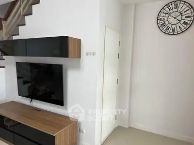 Modern living room with sleek TV unit and stylish wall clock, perfect for contemporary homes.