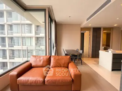 Modern living room with leather sofa and large windows in a high-rise apartment