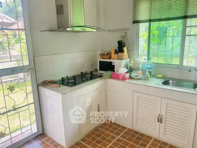 Charming kitchen with gas stove and garden view, perfect for culinary enthusiasts.