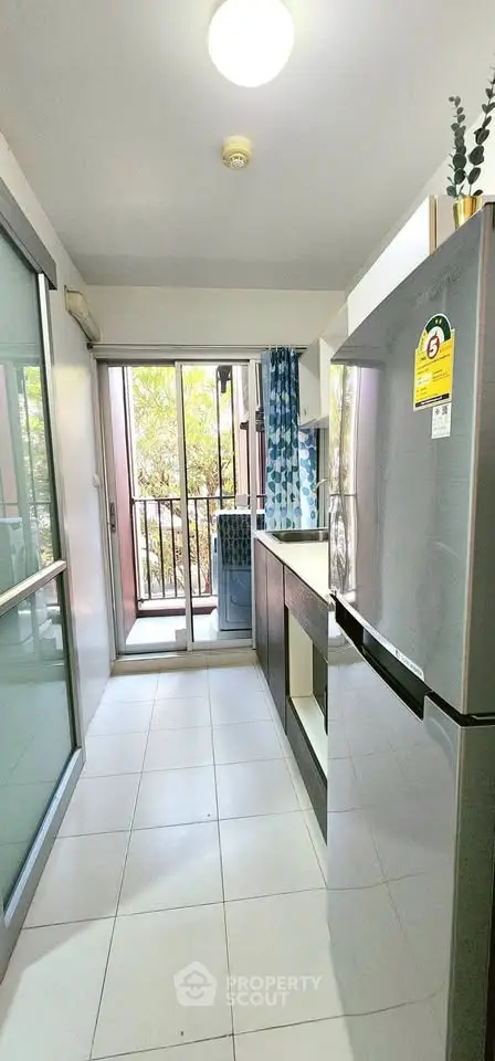 Modern kitchen with sleek appliances and balcony view, perfect for urban living.