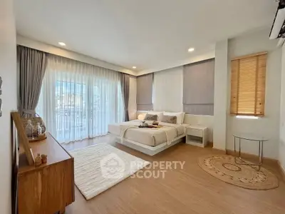 Spacious modern bedroom with elegant decor and large windows for natural light.