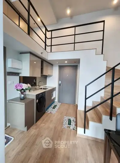 Modern loft apartment with stylish kitchen and wooden staircase