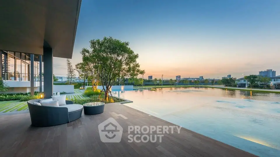Luxurious modern patio with stunning lake view and elegant outdoor seating at sunset.