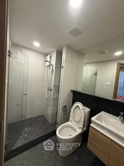 Modern bathroom with glass shower and sleek fixtures in a contemporary apartment.