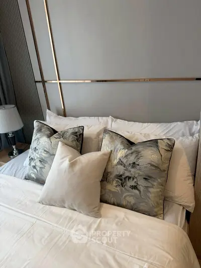 Luxurious bedroom with elegant pillows and modern decor, perfect for relaxation.