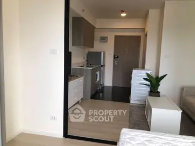 Modern studio apartment with compact kitchen and cozy living area.