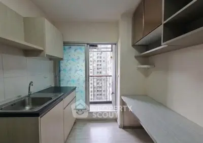 Modern kitchen with sleek cabinetry and balcony view in urban apartment