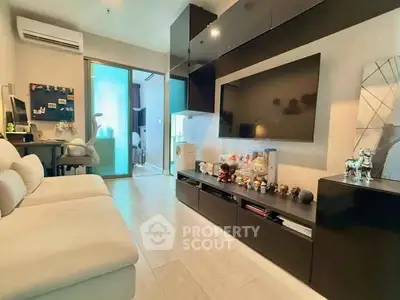Modern living room with sleek black furniture and large TV, ideal for urban living.